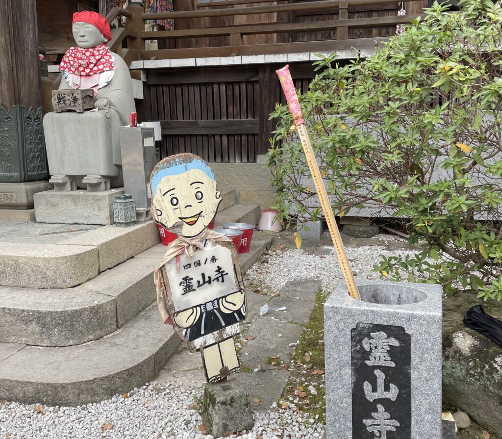 札所案内の小坊主看板。朽ちているし表情も虚ろでホラー。