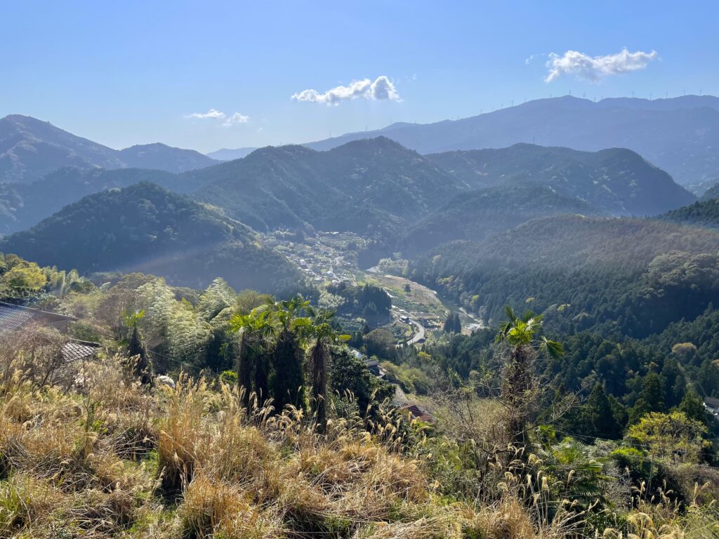 連なる山々と下の集落を見渡す