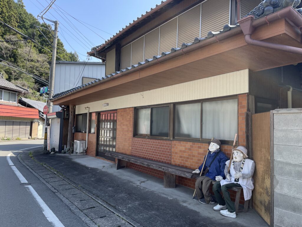民家の軒先で休憩中のお遍路さん（かかし）