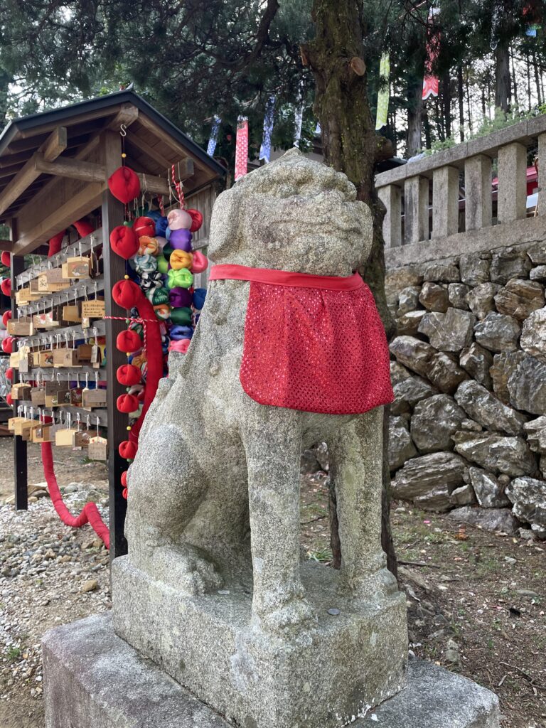 赤い前掛けの狛犬