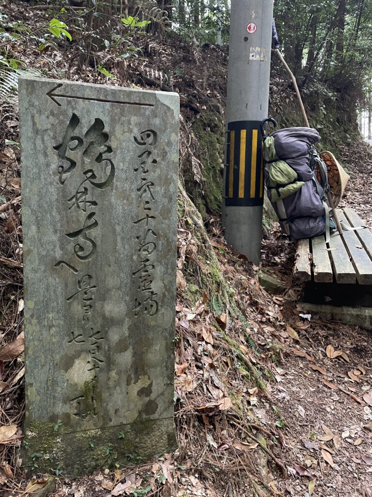 黒い石に流麗な字体の道しるべ