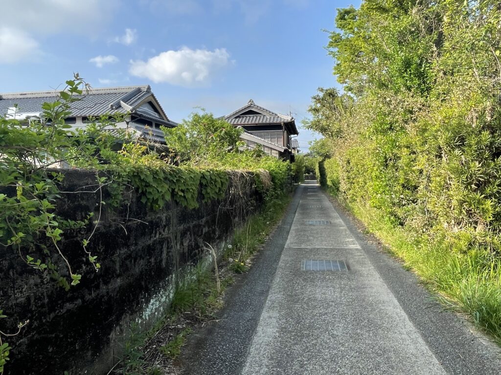 高い生垣と瓦屋根の屋敷が並ぶ